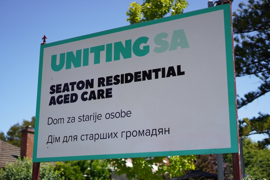 A sign outside an aged care home in English, Polish and Russian