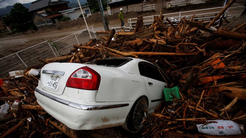 Debris and a car which were swept by heavy rain are seen in Asakura, Fukuoka Prefecture