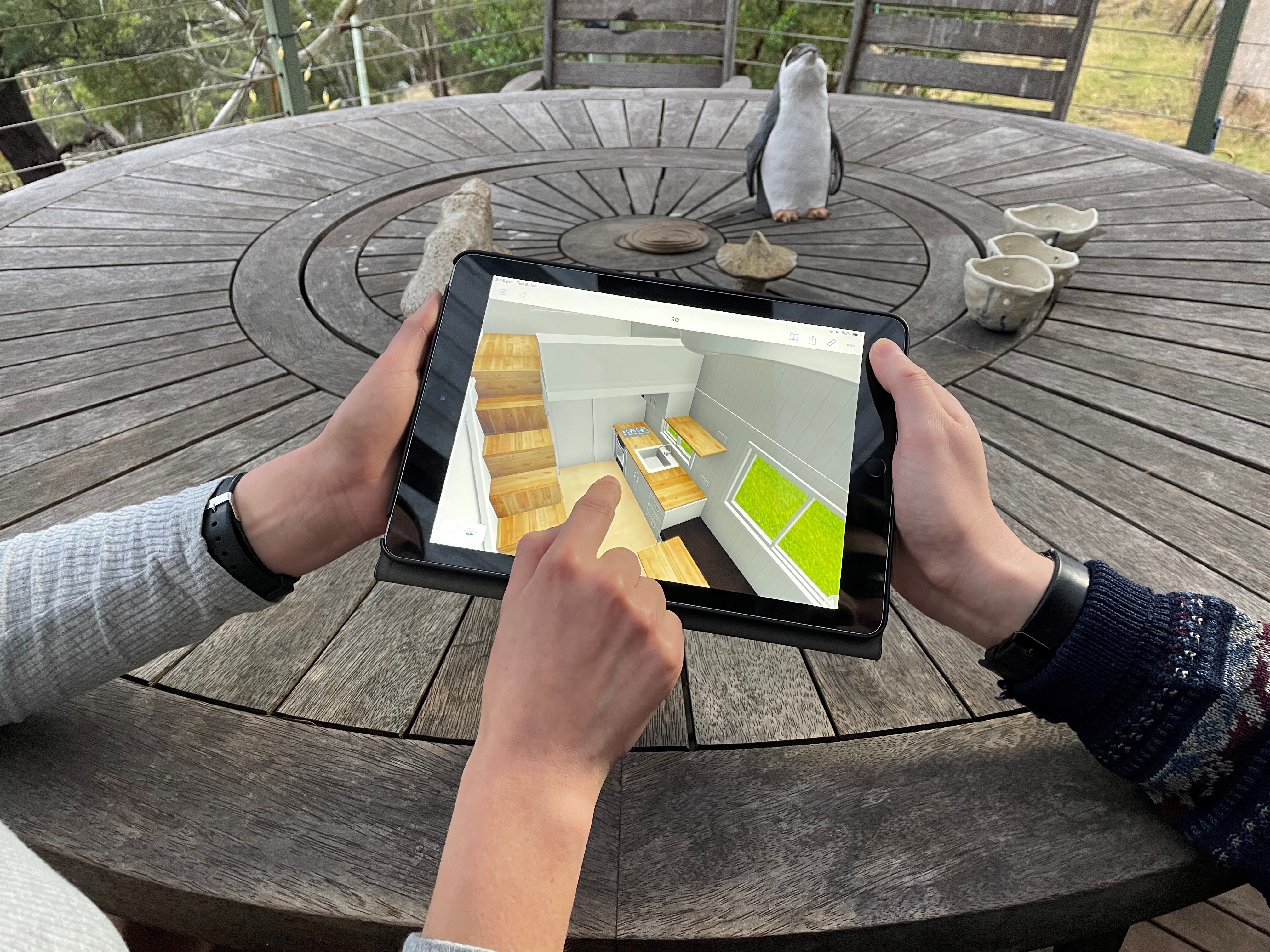 An iPad with an animated model of a kitchen on it.