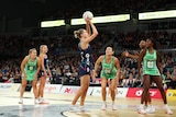 A Melbourne Vixens Super Netballer gets ready to shoot the ball as West Coast Fever defenders watch.