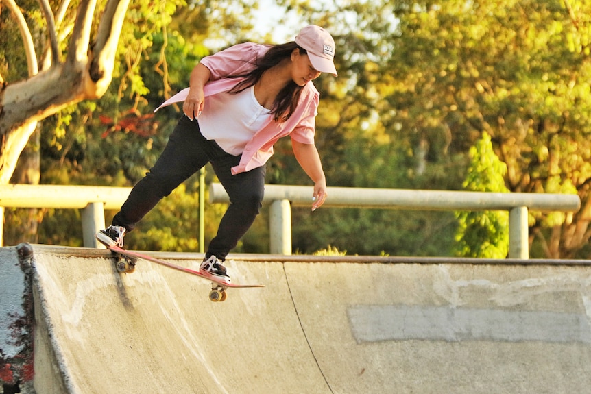 A middle-aged woman skateboarding.