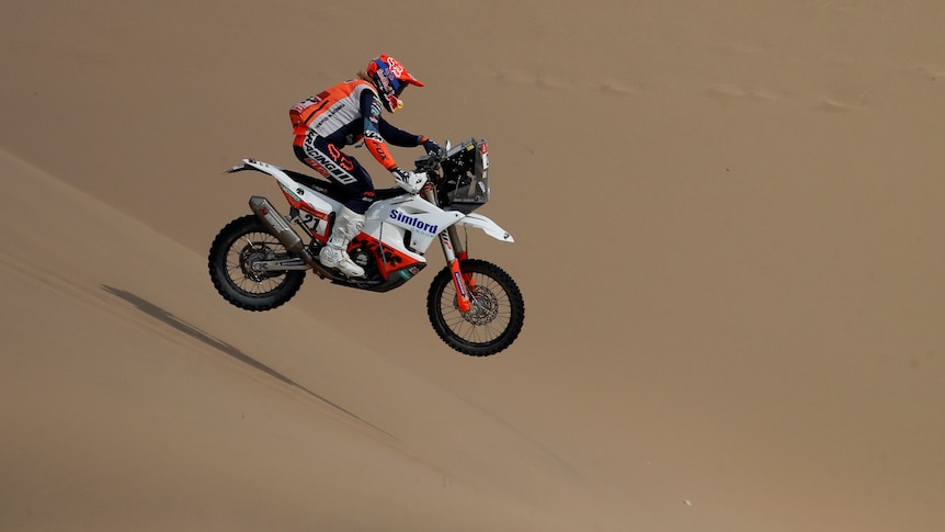 Daniel Sanders rides his bike over sand dunes