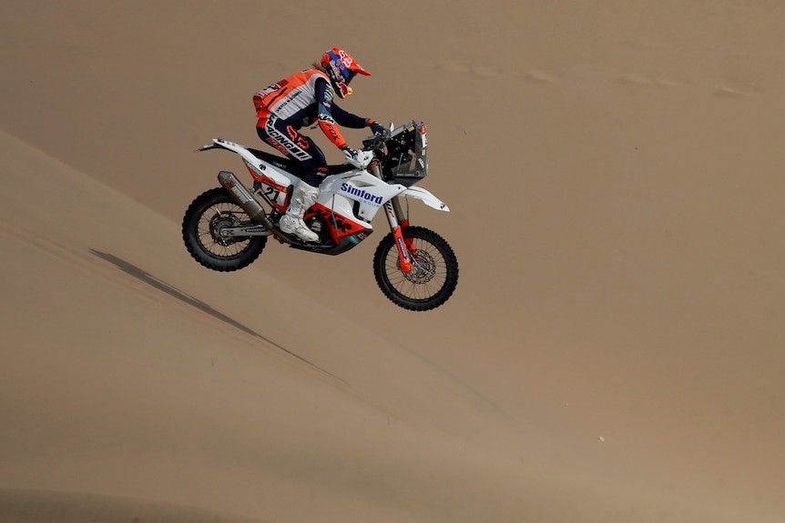 Daniel Sanders rides his bike over sand dunes