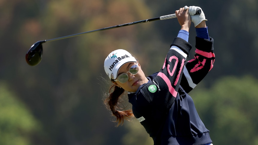 Minjee Lee drives the ball on the fourth hole. She wears a hat, sunglasses and long-sleeve top