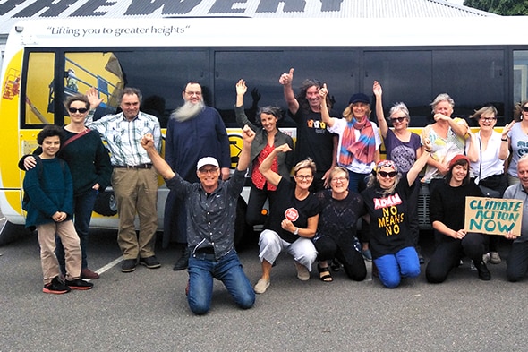 A group of people with signs in front of a bus