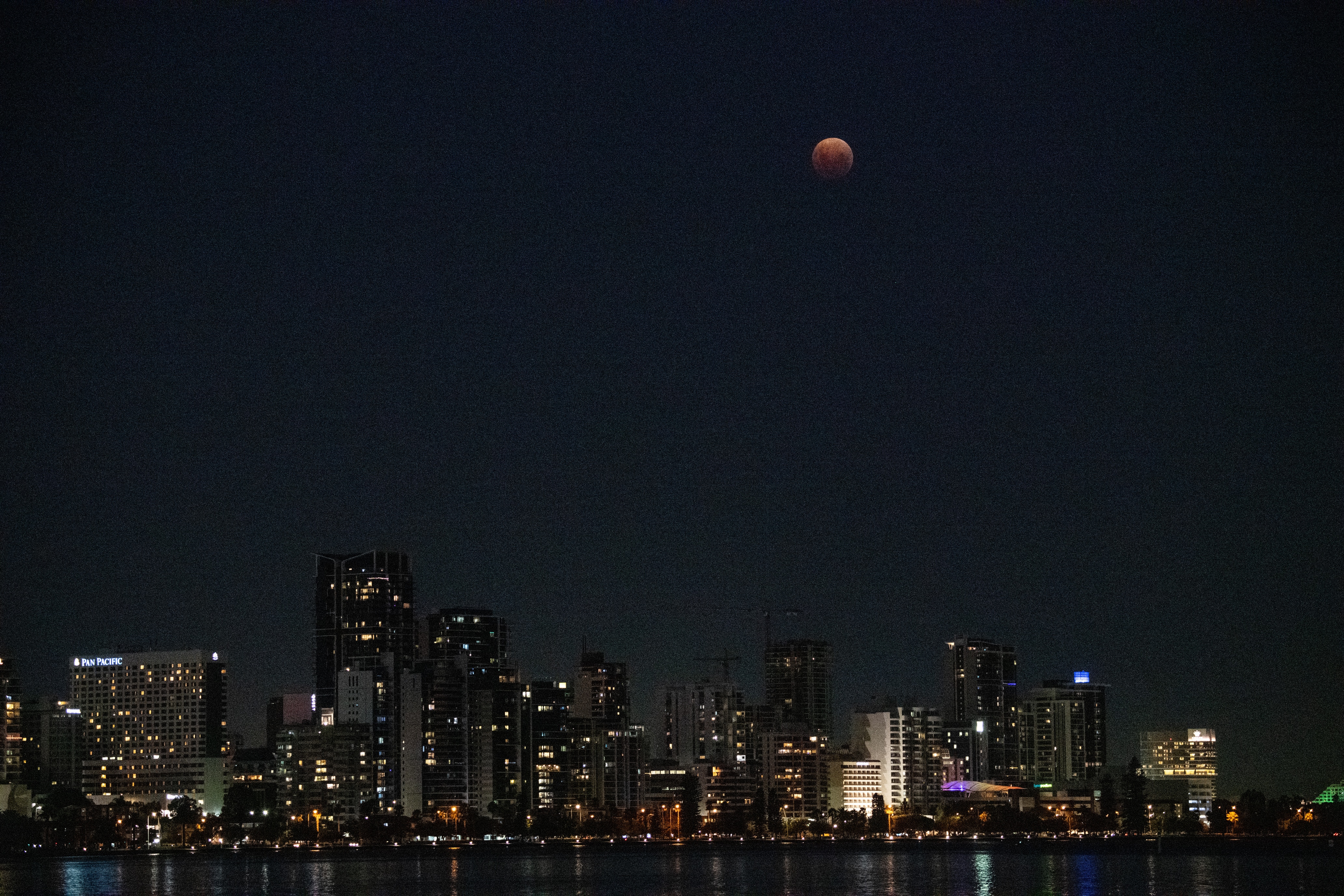 Una toma de gran angular de la luna naranja mientras se produce un eclipse lunar en Perth. 