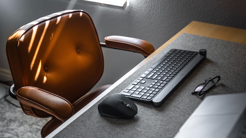Empty chair next to a desk with a computer keyboard and mouse