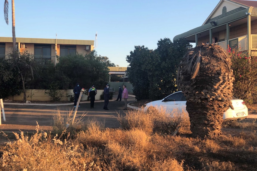 A handful of police officers standing outside the Hedland hotel.