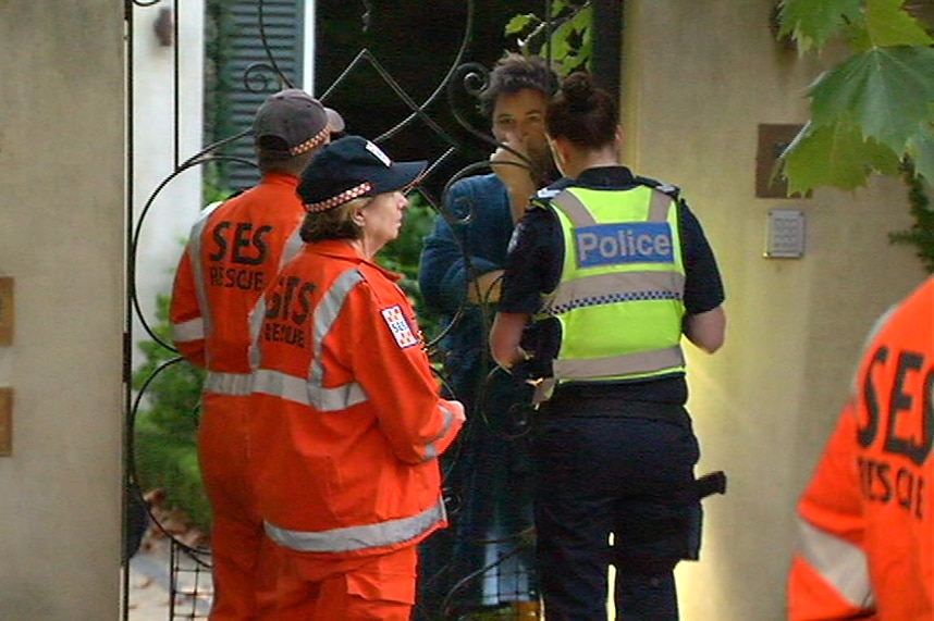 Police and SES officers speak to a neighbour in Malvern.