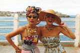 Jenny Kee and Linda Jackson in the 1970s on a pier at the beach wearing their signature colourful clothing.
