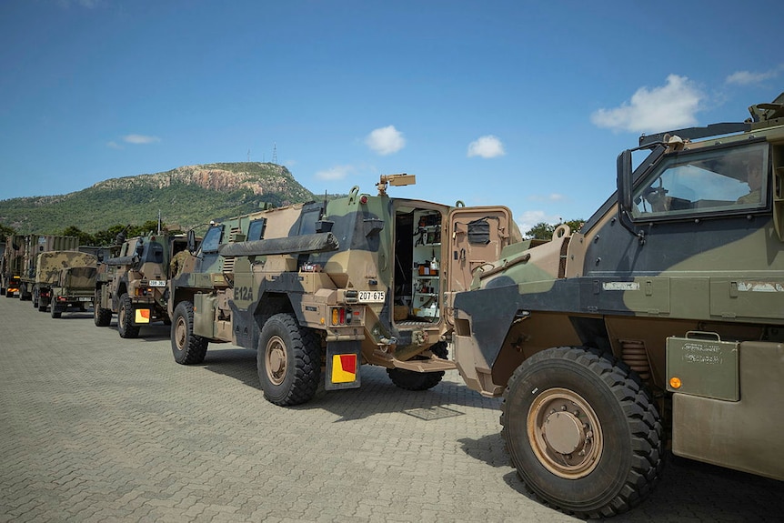 A row of armoured vehicles in camouflage paint