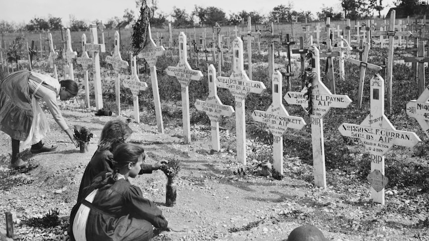 Three young French girls lay tributes at the graves fallen Australian soldiers 