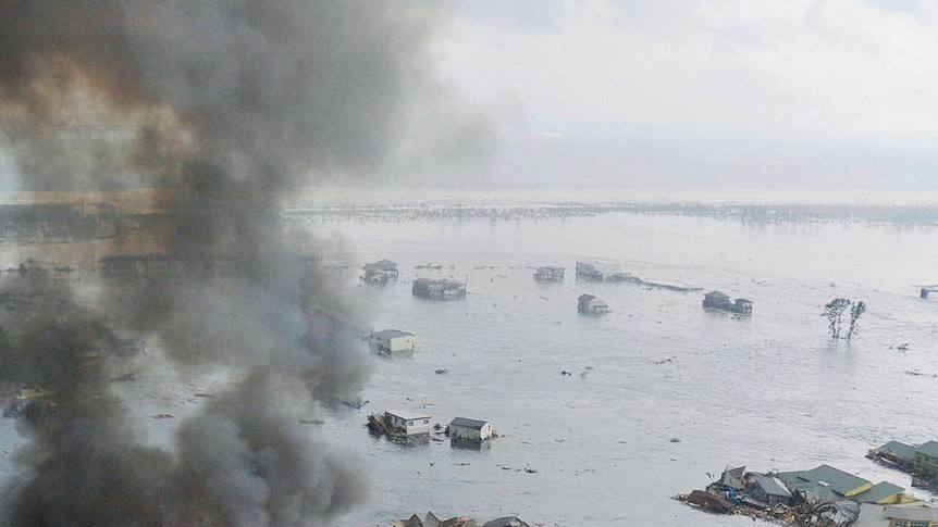 Burning houses swept away in tsunami