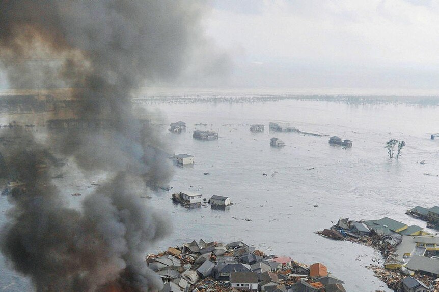 Burning houses swept away in tsunami