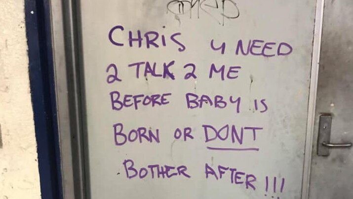 Graffiti on a silver door reads 'Chris u need 2 talk 2 me b4 baby is born or dont bother after'.