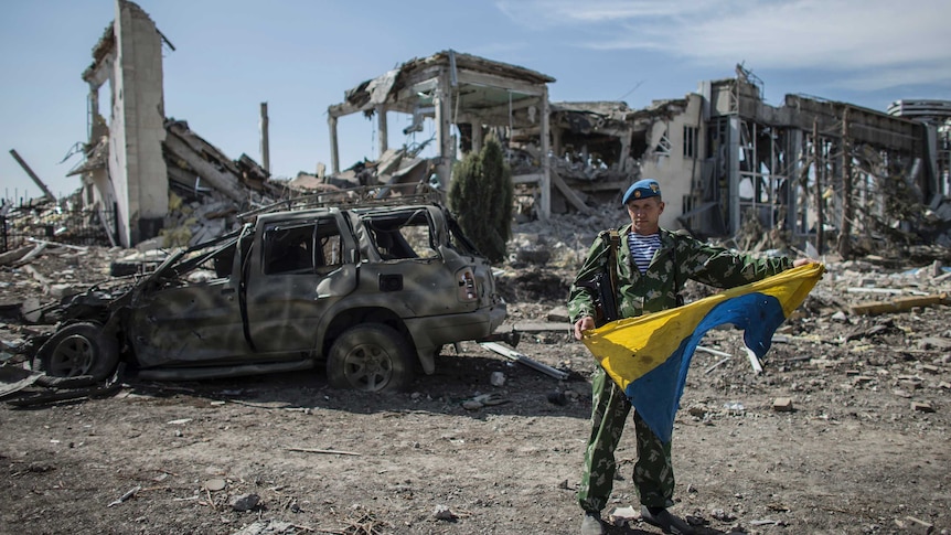 Pro-Russian rebel displays seized Ukrainian flag in Luhansk
