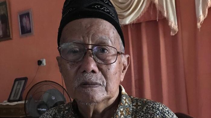 Elderly Indonesian man Andi Monji poses for a photo.