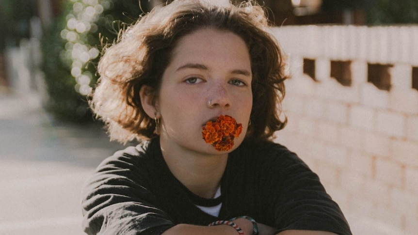 Press shot of Sydney artist MAY-A; subject with flower in her mouth