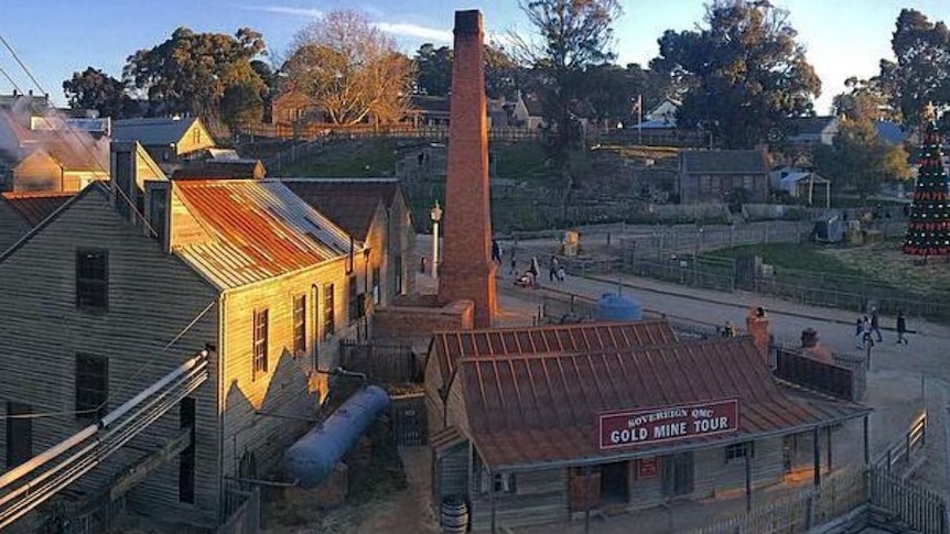 An aerial view of the goldfields museum Sovereign Hill at Ballarat showing a big chimney and old weatherboard buildings.