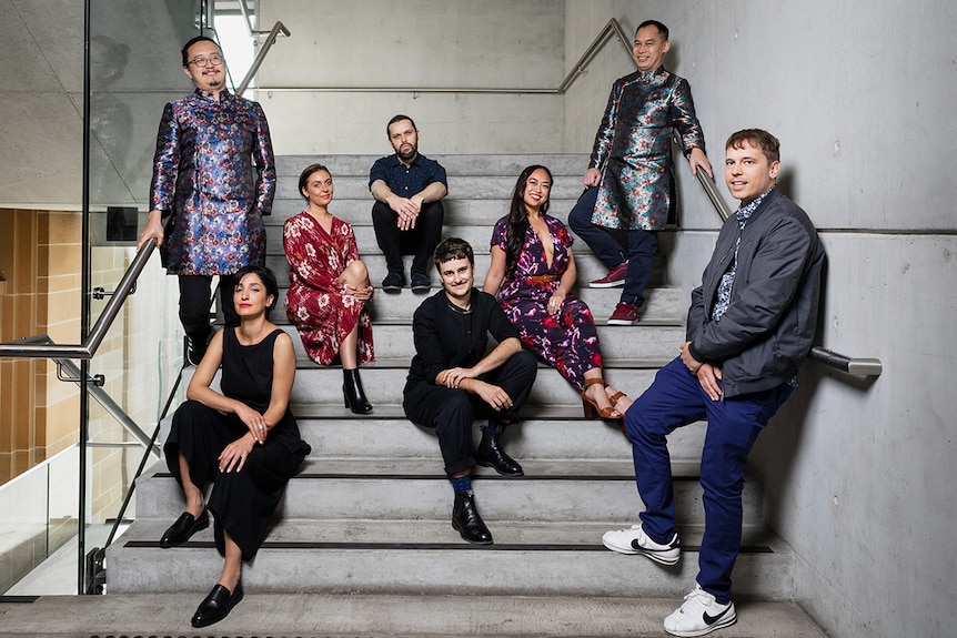 Colour photo of the 2018 Museum of Contemporary Art annual exhibition of young Australian artists posing on concrete stairs.