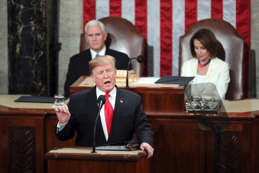 Donald Trump speaks and gestures with his hand.