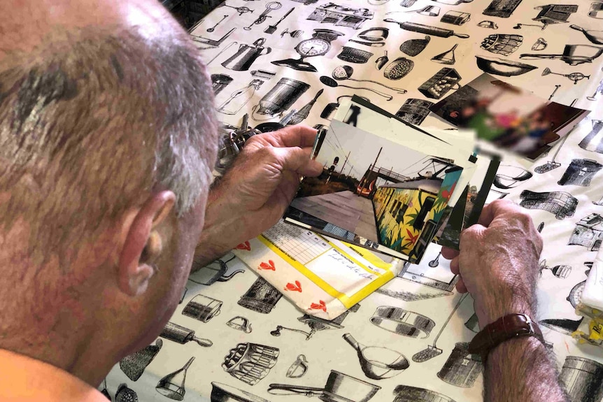 A man looking down at photos.