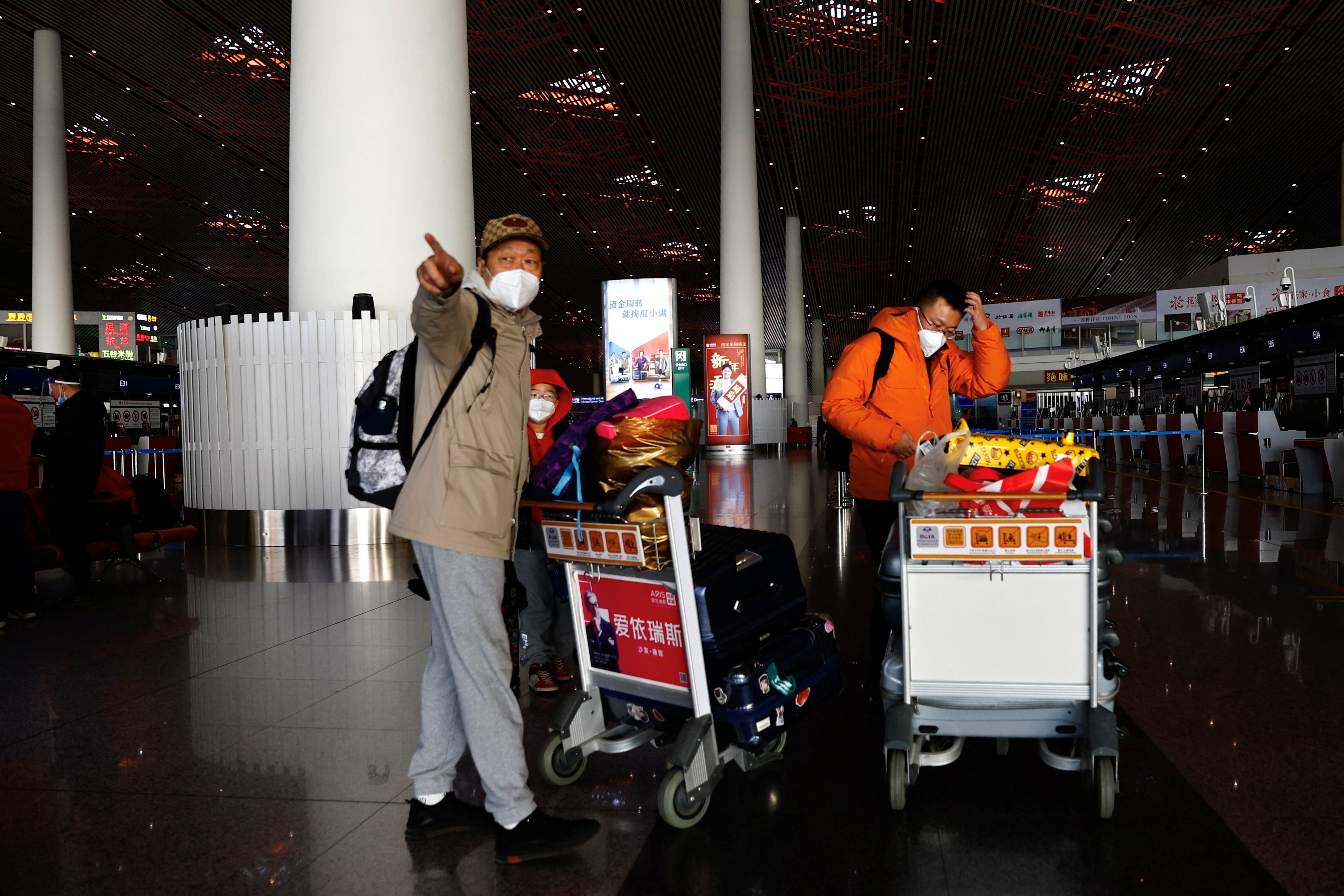 Two people wearing face masks at Beijing airport