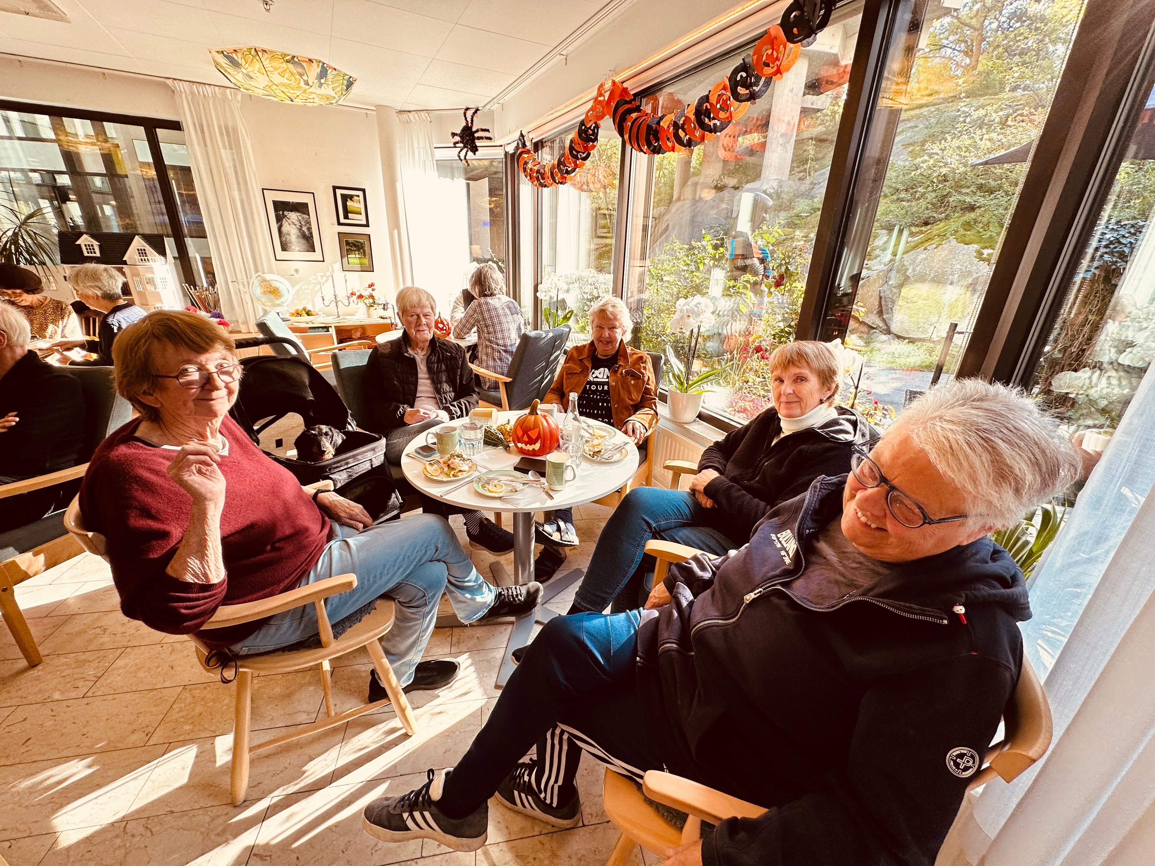 Group of men and women at an indoor cafe smile at the camera 