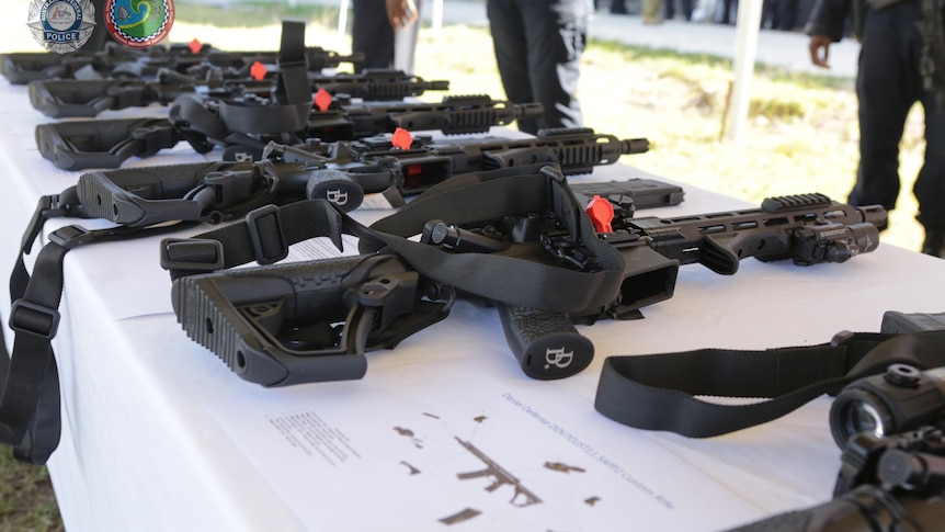 Semi-automatic rifles lay on a table.