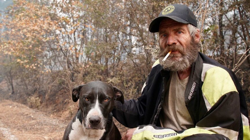 A rugged-looking man with a dog