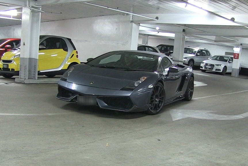 Lamborghini is seized by police in a car park.