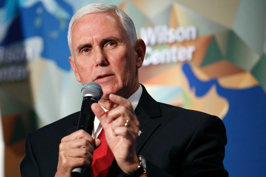 Vice President Mike Pence gestures as he speaks into a microphone.