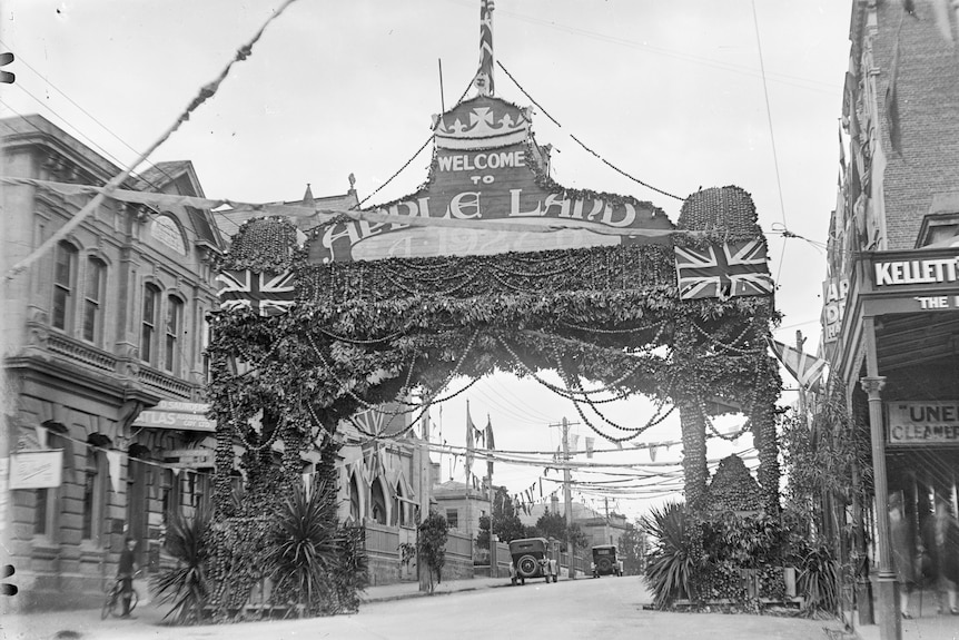 A black and white photo of an arch made from apples that says 'welcome to apple land'
