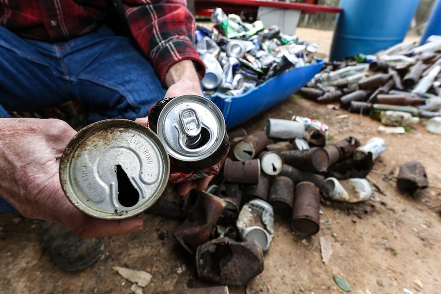 Bill holding two cans of drink, one from the 1980s and a latest version.