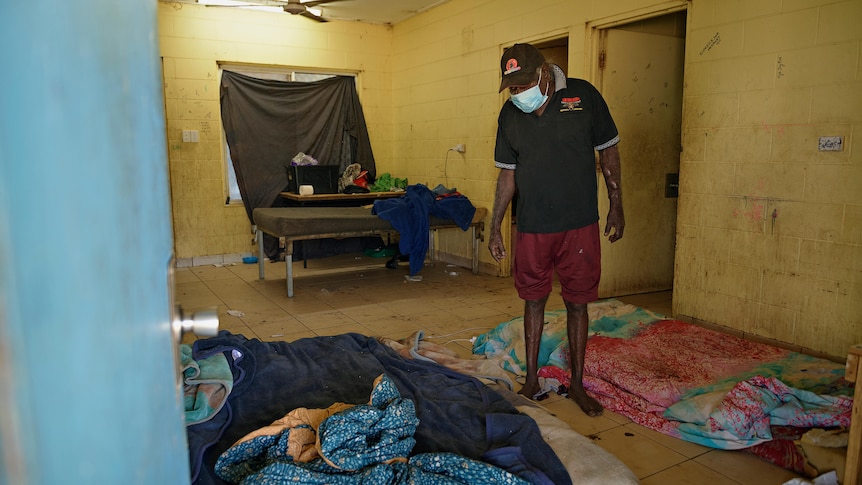 A man stands in his living room in Rockhole. 