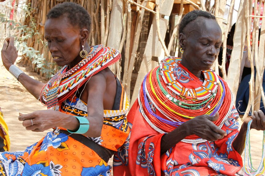 two women in the village of Umoja string beads 