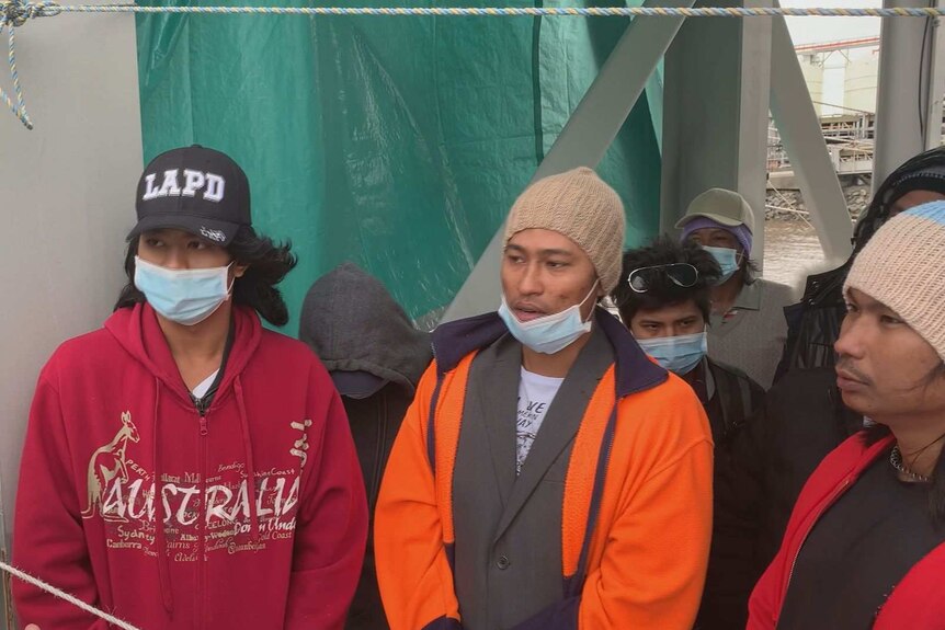 Seafarers wearing masks talk to union officials