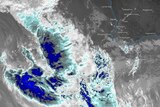 A black and white satellite image showing a big blue storm system off WA's coast.