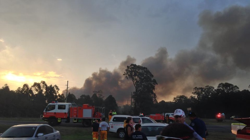 Smoke billows behind fire crews fighting the Aberdare fire at Cessnock in the Hunter region of NSW.