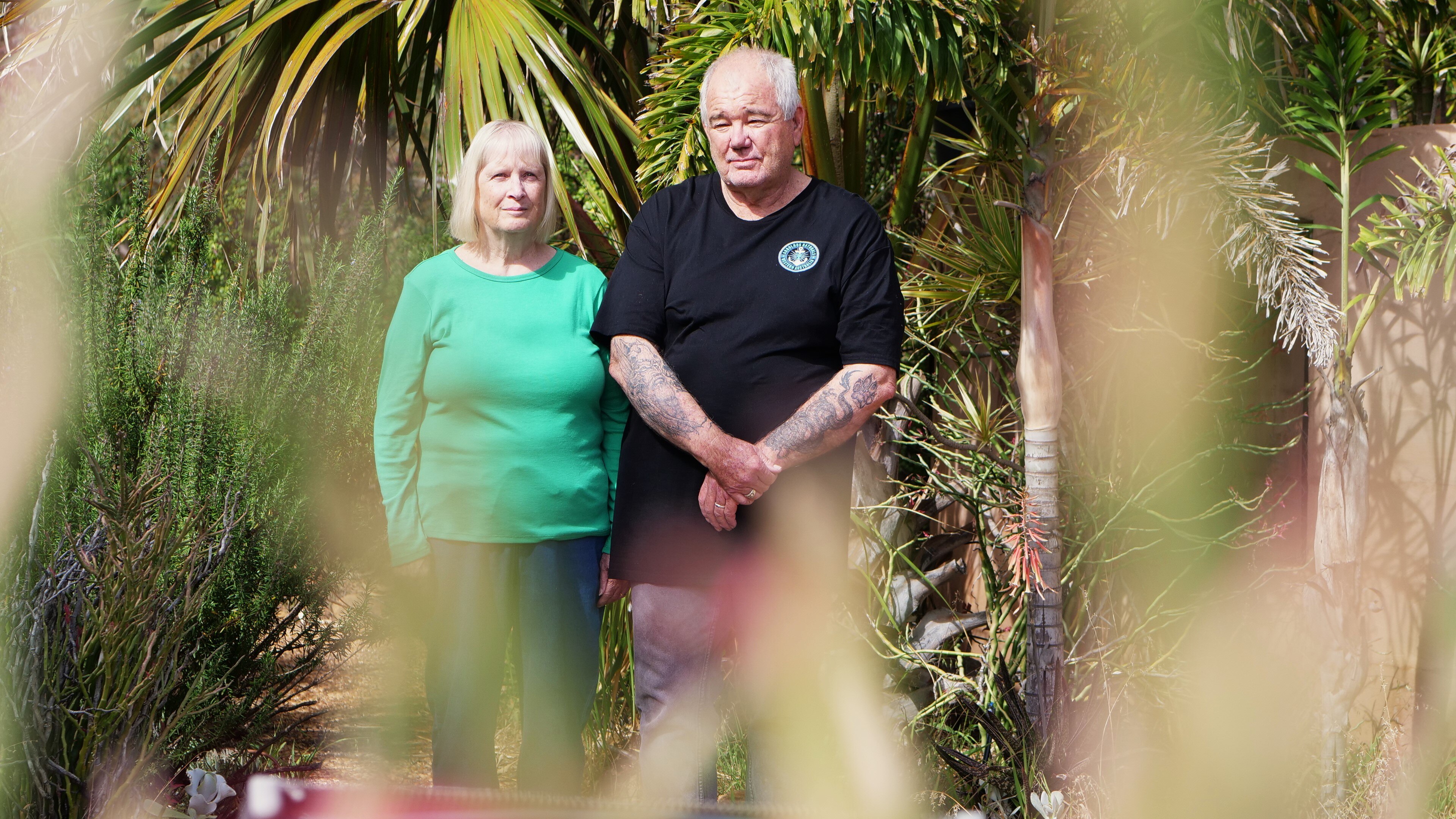 woman and man stand in garden looking at the camera