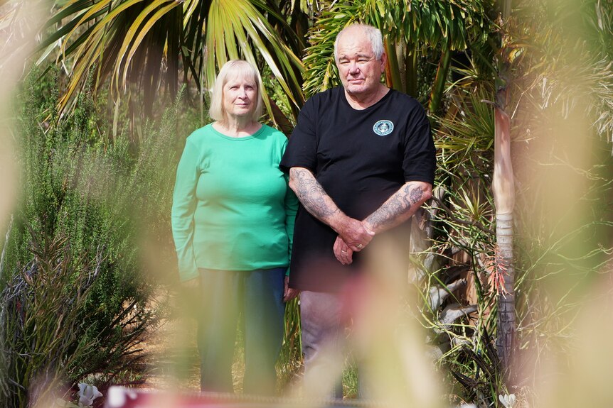 woman and man stand in garden looking at the camera