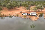 A caravan beside a rock pool in outback Queensland.