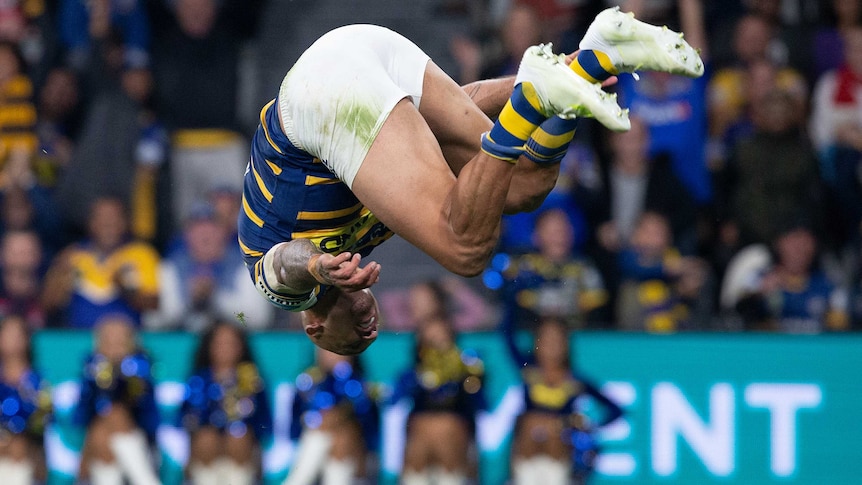 Blake Ferguson looks at the ground in mid-air as he does a back flip following a try for the Eels.