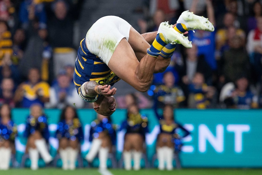 Blake Ferguson looks at the ground in mid-air as he does a back flip following a try for the Eels.