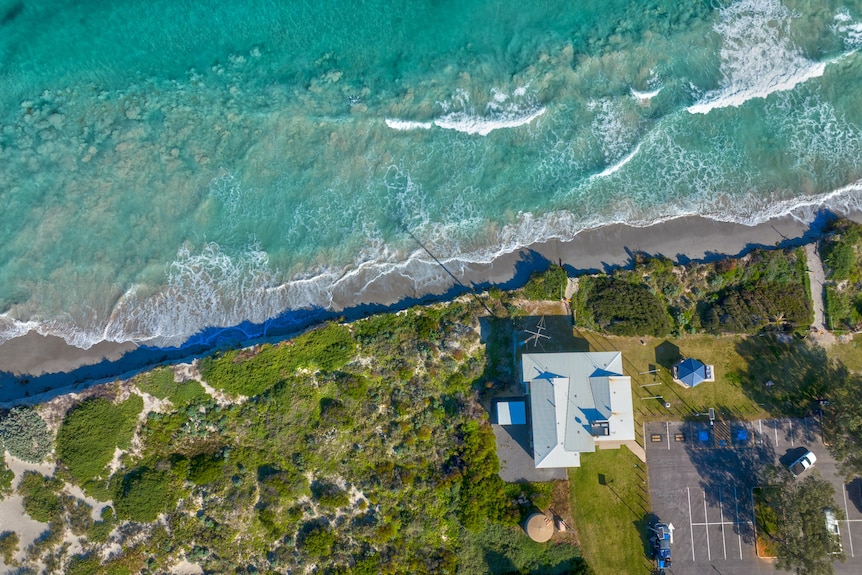 An aerial shot of a building close to the ocean