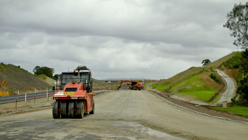 Roller machine working on newly laid road of the Pacific Highway in Northern New South Wales.