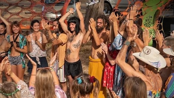 A group of people dance at an outdoor gathering