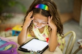 Young girl looking at a tablet device.