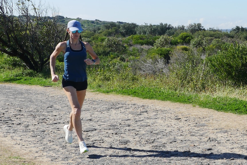 A woman on a running track on a headland.