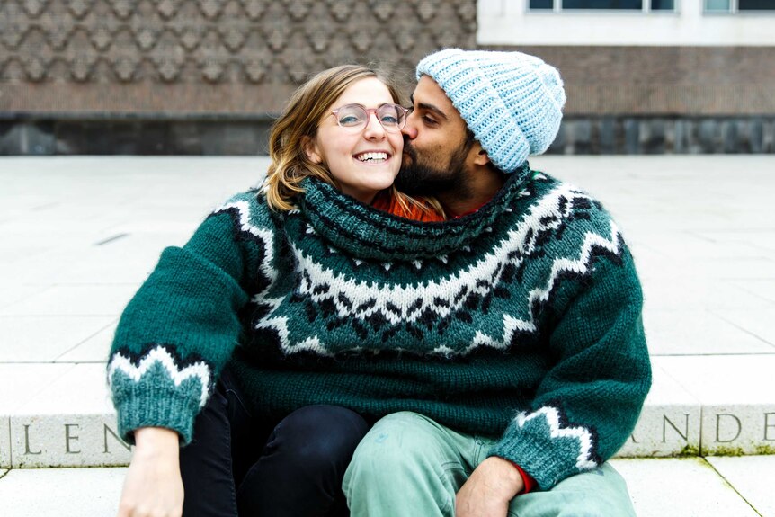 A couple share the same oversized jumper.